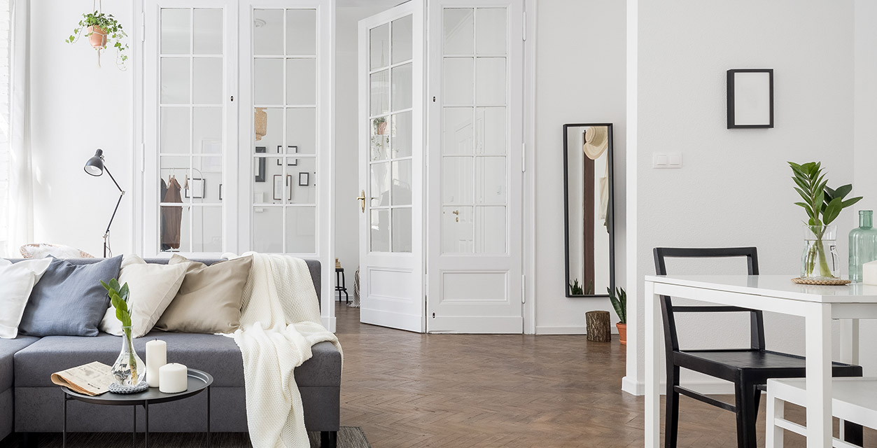 modernes helles Wohnzimmer mit weißem Raumteiler als Tür