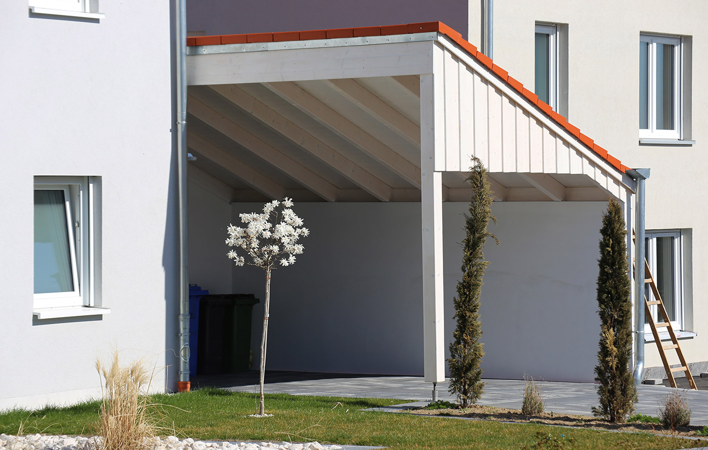 Carport aus Holz zwischen zwei Häusern